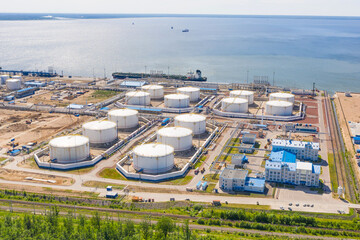 Fototapeta premium Business commercial trade fuel and energy transport by tanker vessel. Aerial view storage tank farm at night, Tank farm storage chemical petroleum petrochemical refinery product at oil terminal.