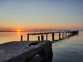 Fototapeta na wymiar Sunset on the lake near landing stage 