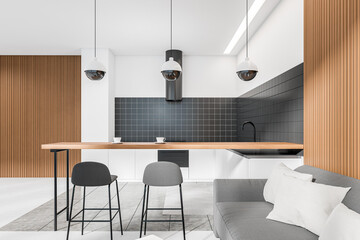 Light kitchen interior with couch and island, lounge zone and eating space