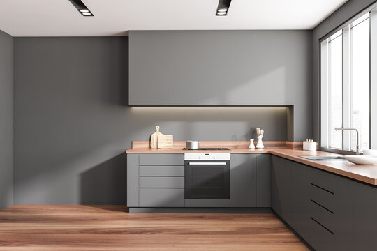 Front view on dark kitchen interior with empty grey wall