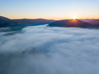Sunrise over the fog in the Ukrainian Carpathians. Aerial drone view.