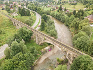 Fototapeta premium Old railway bridge in the mountains. Ukrainian Carpathians. Aerial drone view.