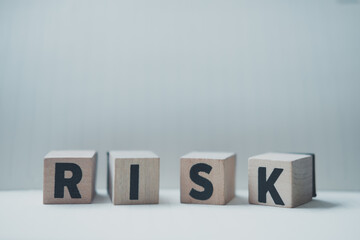 A row of four cubes on a table with a letter R, I, S, K on each cubes.