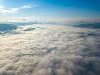 Fototapeta premium High flight above the clouds in the mountains. Aerial drone view.