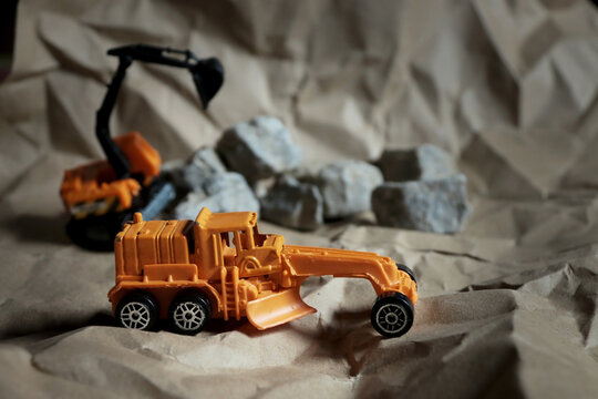 Toy grader on the brown floor, construction background.