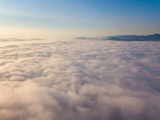 Fototapeta na wymiar High flight above the clouds. Aerial drone view.