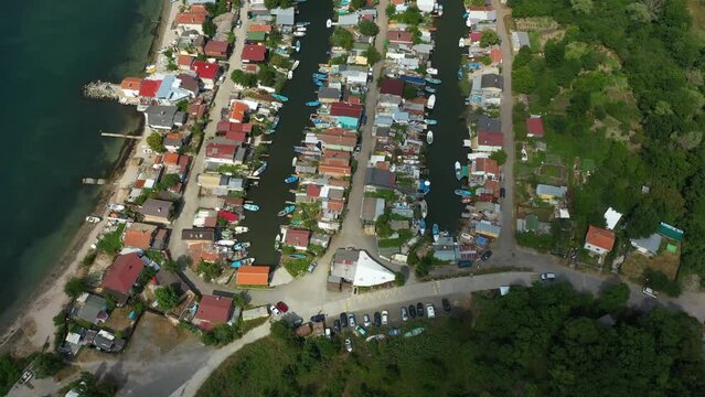 Fishing cottage with boat hus cabins at the ocean or sea on small sandy island. Villages or town of wooden houses in Chengene Skele in Burgas, Bulgaria. Aerial drone flight over a fishing village. Anc