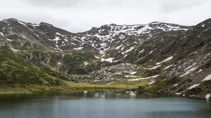 Fototapeta na wymiar Mountain lake reflecting the snowy mountain on it