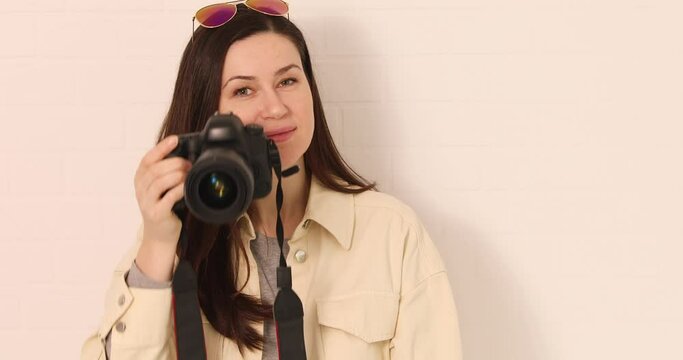 Woman holds a camera in front of the eye and takes a picture. Photographer at work. Enjoy taking pictures 