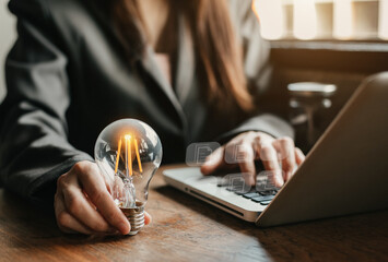 Businessmen carry light bulbs with the idea of saving money, working with laptops and tabs at work...