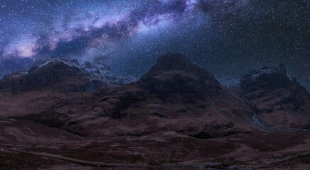 Majesitc vibrant Milky Way composite image over landscape of Three Sisters mountains in Glencoe in Scottish Highlands