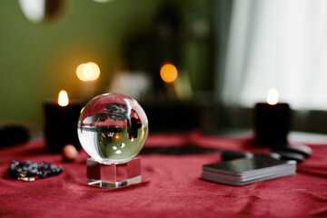 Background image of crystal ball and tarot cards on red velvet table in fortune tellers shop, copy...