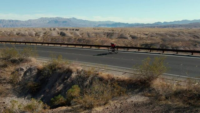 Man bikes alone in the desert (Side Angle)