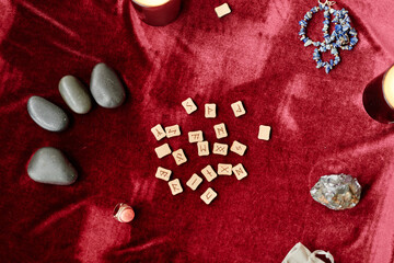 Top view background of runes and spiritual stones on red velvet table in fortune tellers shop, copy space