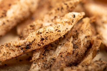 thinly sliced homemade lard with pepper on white oiled paper, close-up, selective focus.