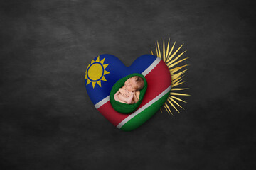 Newborn portrait on heart in color of national flag. Photography peace concept. Namibia