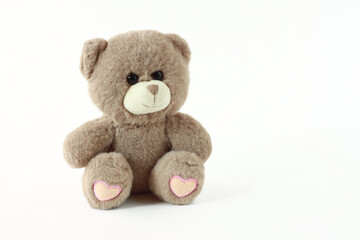 Cute teddy bear toy on a white background. Side view of a bear plush toy on a white isolated background.