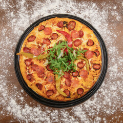 Big tasty pizza with salami hot pepper and arugula