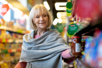 Portrait of beautiful senior lady doing grocery at supermarket