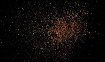 Fototapeta na wymiar Ground, milled nutmeg powder isolated on black, top view