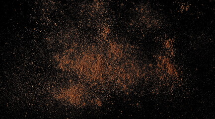 Ground, milled nutmeg powder isolated on black, top view