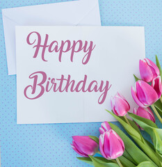 white card and envelope on blue ground with tulips with space for text