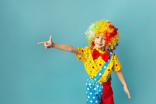 Funny Kid Clown Against Blue Background. Happy Child Playing With Festive Decor. 1 April Fool's Day Or Birthday Concept