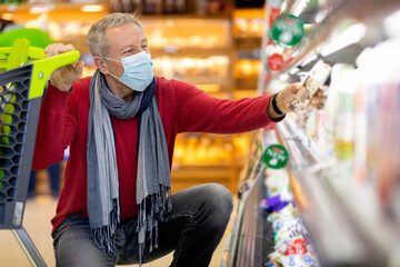 Fototapeta premium Senior man in face mask customer shopping while coronavirus pandemic