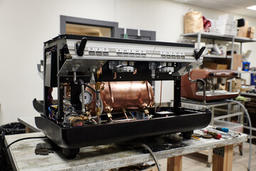 a professional coffee machine stands in a repair shop without a case with visible insides