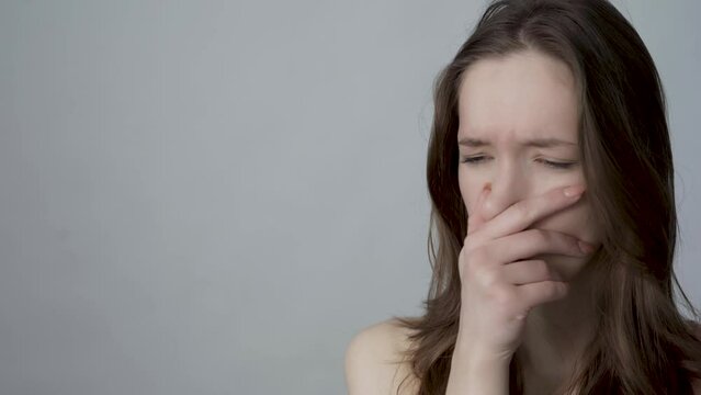 young woman closes nose because of a bad smell