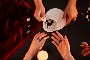 Top down view at female fortune teller reading coffee telling destiny in seance with young woman,...