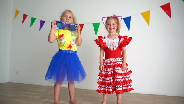 Emotional redhead and blond girls simper with huge colorful glasses. Best friends laughing together. True positive emotions. Smooth camera motion shot with gimbal.