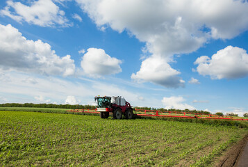 Agricultural tractor spraying the field