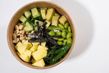 fresh bowl with mango, green beans, nuts, seaweed and avocado