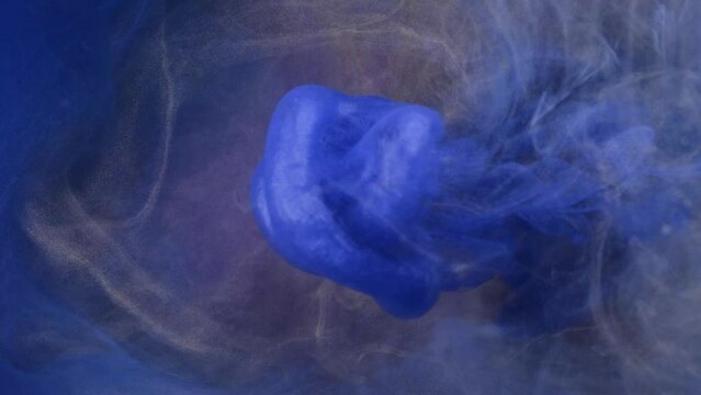 Blue, yellow, gold ink spreading in water. Colored acrylic cloud abstract smoke background. Glitter fluid motion. 