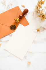 Autumn flat lay composition with wedding invitation card mockup, envelopes, dried flowers on marble table.