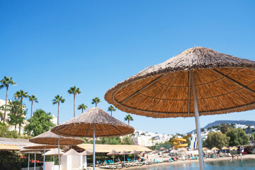 Beach umbrellas and deck chairs on the beach at a tropical resort for summer holidays