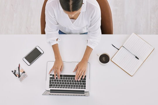 Young Woman Stern With Hunger. Above Shot Of A Businesswoman Using A Laptop At A Desk In A Modern Office.