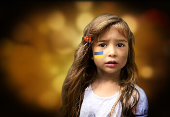 Child with the flag of Ukraine on face. Sadness longing hope. Portrait macro. Children's tears from the war. Evacuation of civilians. Freedom to Ukraine - 495235934