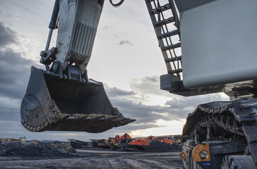 Big excavator in coal mine at cloudy day, low angle view