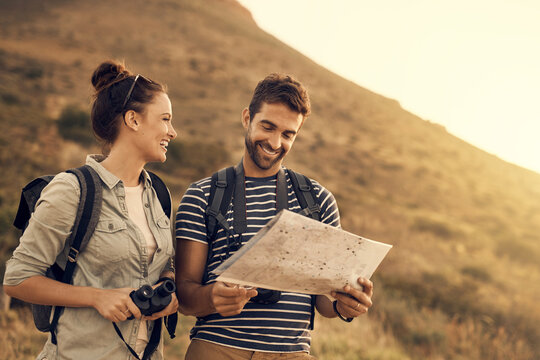 Do you even understand maps, babe. Shot of a couple looking at a map while out hiking.