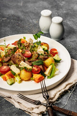 Steak salad with vegetables, cheese and herbs. Delicious and healthy lunch or dinner recipe. Beef meat with sweet Bavarian mustard. Two forks and spices. Close-up. Vertical shot
