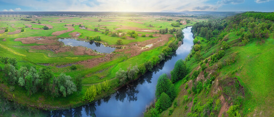 Panorama of a river flowing in a green valley
