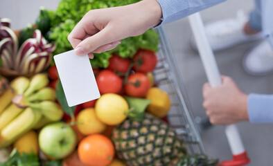 Woman pushing a trolley and holding a blank card