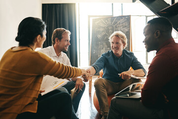 In it for the betterment of business. Shot of designers shaking hands during a meeting in an office.