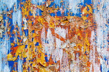 Minimalist colourful textured background of old and rusted whit, blue, brown and orange  paing on metallic surface, in direct sun light in an urban environment.