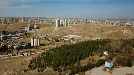 Rural settlement and land. Empty farmland and cityscape in the distance. Rural landscape shot with drone.