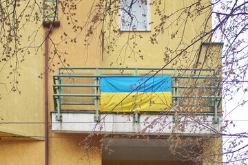 The flag of Ukraine hangs on the balcony. The people hang out flags as a confirmation of the desire to live in their own country, in peace on the whole planet and countering external interference in t