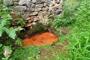 Source ferrugineuse avec de belles couleurs orang&eacute;es sur le chemin de randonn&eacute;e du ravin de Quinsat dans le puy de dome