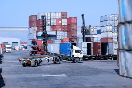 Trucks and container forklifts in the container depot in the import and export area at the port